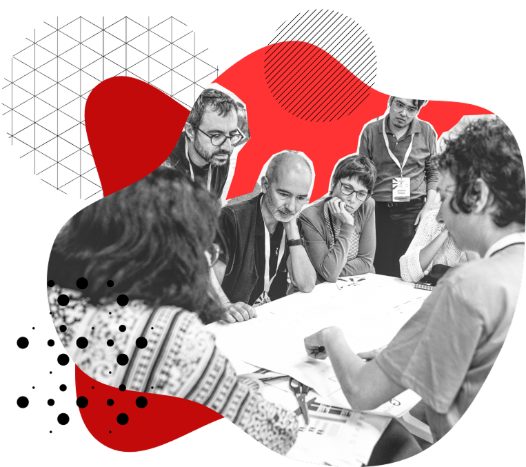 Participants gathered around a table, collaborating on a document during a Decidim community event